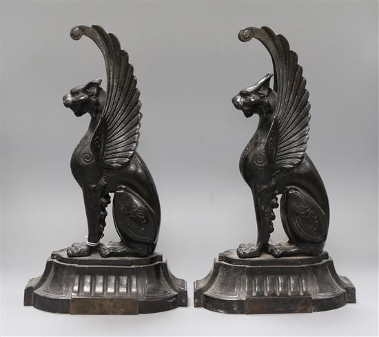 A pair of cast iron griffins height 38cm